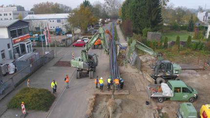 Die Drohnenaufnahme zeigt das 300 Meter lange Rohrbündel unmittelbar vor dem Einzug in den Bohrkanal. Im Vordergrund ist der Bohrkopf zu erkennen.