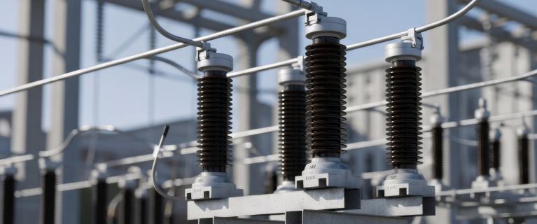 Detailansicht einer elektrischen Umspannanlage mit Isolatoren, Leitungen und Metallkonstruktionen im Freien.