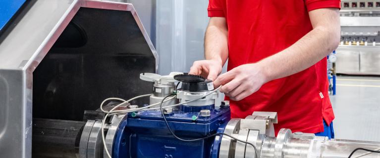 Techniker justiert Messgerät an Prüfstand im Labor.