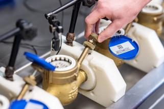 Hand justiert Ventil an Messgerät-Prüfstand.