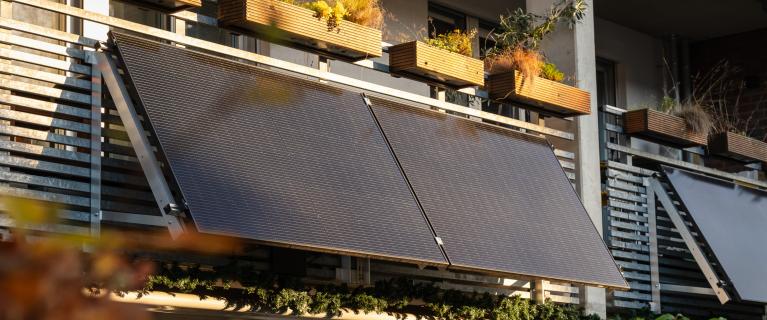 Solarmodule an Balkonbrüstung eines Mehrfamilienhauses.
