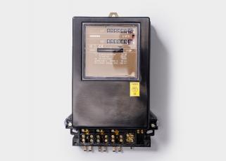 Schwarzer Ferraris-Zähler mit Zählwerk und Anschlussklemmen unten.